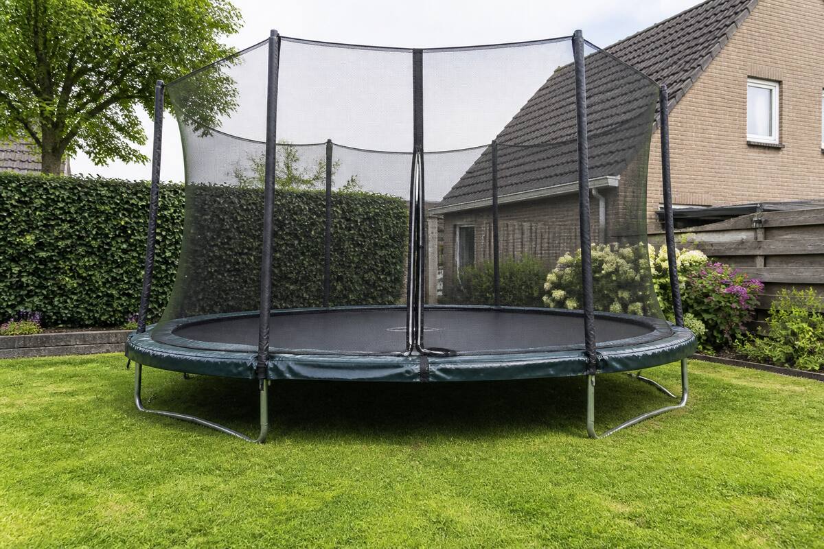 Trampoline met veiligheidsnet in een achtertuin, fotorealistische weergave
